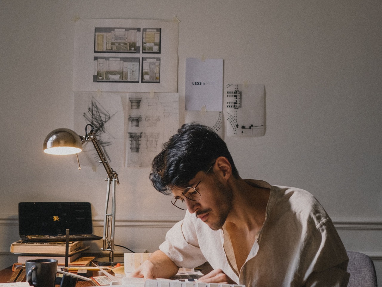 An architect reviewing plans and color samples at a desk